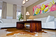 Obývacímu prostoru v tlumených odstínech dominuje pestrobarevný obraz, který byl zhotoven na míru pro tento interiér. 