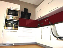 Obývací pokoj s kuchyní je navržen pro studentku, která si přála moderní černo bílou kombinaci nábytku ve vysokém lesku. Aby místnost nevypadala příliš neosobně, rozzářili jsme ji červenými doplňky.