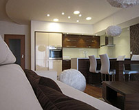 Obývací pokoj s kuchyní propojuje motiv kruhu a koulí – ty naleznete na lustrech z husího peří nebo třeba půlkruhovém stropním sádrokartonovém podhledu.