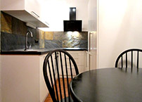 Nadčasová černobílá kombinace doplňuje černý jídelní stůl.